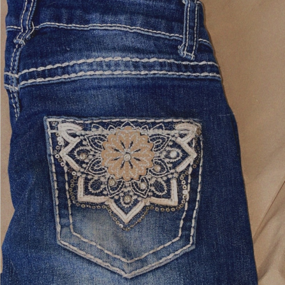 Bootcut dark blue jeans with white design on pockets